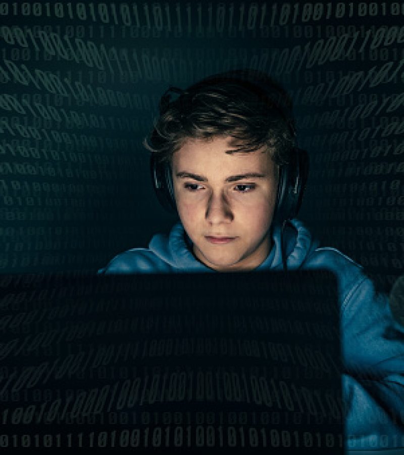Teenager focused on computer display. Green numbers on background. Login with credentials user and password. Technology communication, security protection intrusion, hacker attack, cyber crime concept